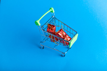 Christmas presents shopping concept. Basket and christmas accessories. Christmas basket with presents. Onlain shopping. On a blue background. place for writing.