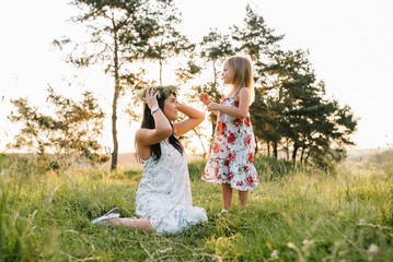 Obraz premium Stylish mother and handsome daughter having fun on the nature. Happy family concept. Beauty nature scene with family outdoor lifestyle. family resting together. Happiness in family life. Mothers day
