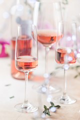 Different glasses and bottle of rose wine on light background.