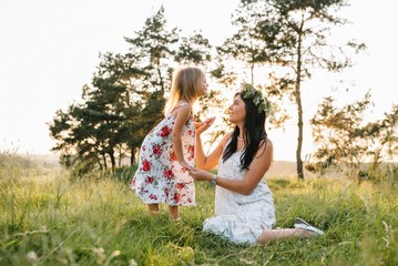 Naklejka premium Mother and daughter having fun in the park. Happiness and harmony in family life. Beauty nature scene with family outdoor lifestyle.