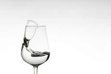 beautiful splashes of water in a wine glass, isolate on white, close up with copy space.