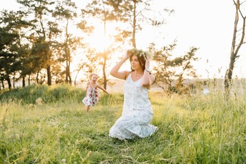 Fototapeta na wymiar Stylish mother and handsome daughter having fun on the nature. Happy family concept. Beauty nature scene with family outdoor lifestyle. family resting together. Happiness in family life. Mothers day