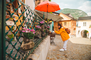 woman taking picture on her phone at hallstatt city streets