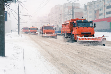 A large snowplow removes snow from the road