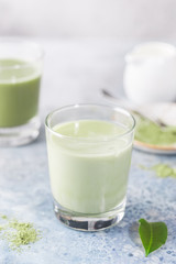 Obraz na płótnie Canvas Iced Matcha green latte in glasses with matcha powder on light background.