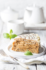 Traditional Hungarian Esterhazy piece of cake on a white wooden background.