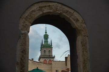 Naklejka premium view of church bell tower through outdoor cafe arch