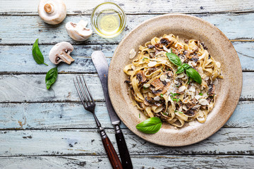 Tagliatelle pasta with mushrooms, cheese and Basil Leaf on the plate, top view - obrazy, fototapety, plakaty