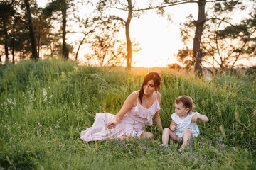 Fototapeta premium Stylish mother and handsome daughter having fun on the nature. Happy family concept. Beauty nature scene with family outdoor lifestyle. family resting together. Happiness in family life. Mothers day