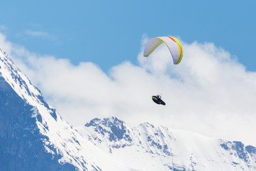 flying paraglider in Swiss alps in Bernese highlands, mountains, snow