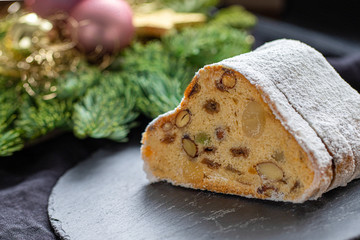 German Christmas Cake with Raisins and Nuts with decoration in the background