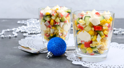 Crab salad. Delicious light salad of crab sticks, corn, fresh cucumbers, eggs in a glass cup. Holiday salad. Dishes for the New Year, Christmas. © yaroshenko