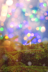 Fir brunch on sparkling background with place for text. New year decoration. Lights. Snowing