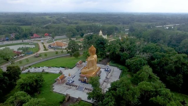 Wide shot aerial drone footage.Flying indirectly from the back of the Buddha.Narathiwat, Thailand Buddha Phra Phuttha Thaksin Ming Mongkol. This Buddha is respected.