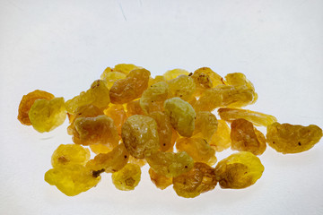 macro shot of dried golden raisins on white background
