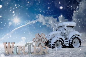 Schriftzug Winter mit eingeschneitem Traktor