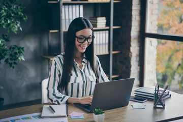 Photo of cheerful toothy beaming intelligent clever business girl looking into screen of notebook...