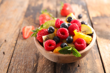 bowl of fruit salad with berry, orange, kiwi and mint