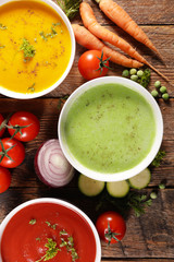 bowl of vegetable soup and ingredient, top view - wood background