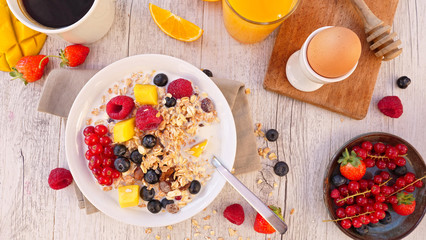 muesli with blueberry, milk and fruit- orange juice and coffee cup