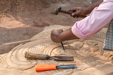 Design work on the wooden planks is underway and the hand of a craftsman is doing it efficiently