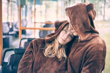 young couple in bear costumes. guy and girl in transport cuddle.