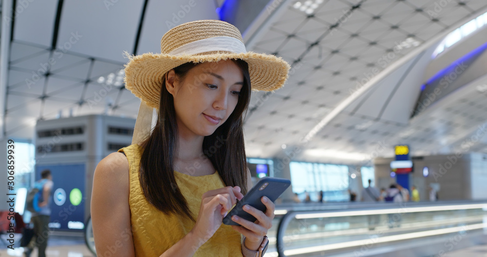 Poster woman check on cellphone in the airport