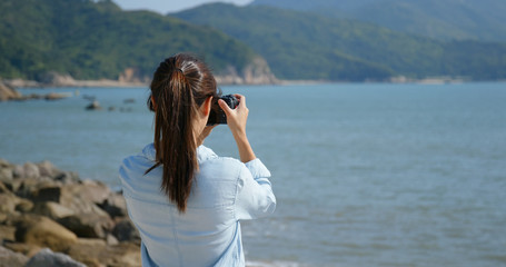 Woman take photo at the sea