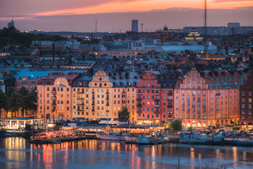 Fototapeta na wymiar Stockholm, Sweden. Skyline View Of Residential Area Houses In Norr Malarstrand Street, Kungsholmen Island. Scenic View In Sunset Twilight Dusk Lights. Evening Lighting.