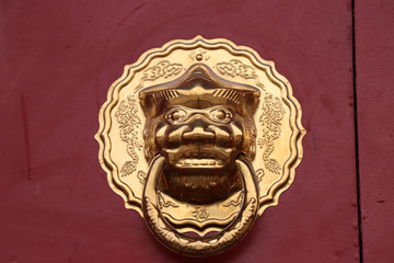 Golden lion head door knocker on red doo , Dacien temple , Xian China.