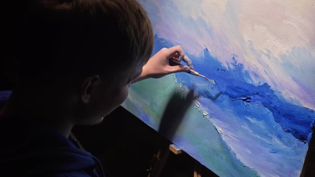 Artist copyist paint seascape with ship in ocean. Craftsman decorator draw as boat sail on blue sea with acrylic oil color. Draw finger, brush, knife palette. Indoor. Dark magic cinematic look.