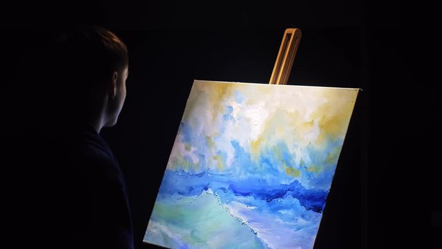 Artist copyist paint seascape with ship in ocean. Craftsman decorator draw as boat sail on blue sea with acrylic oil color. Draw finger, brush, knife palette. Indoor. Dark magic cinematic look.