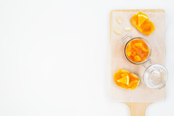 Pumpkin jam with orange on a white table. Horizontal orientation, copy space.