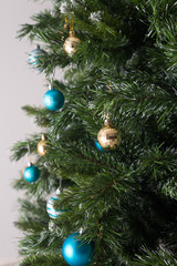 Artificial decorated Christmas tree with balls, ornaments and lights. Festive background for promotion. .
