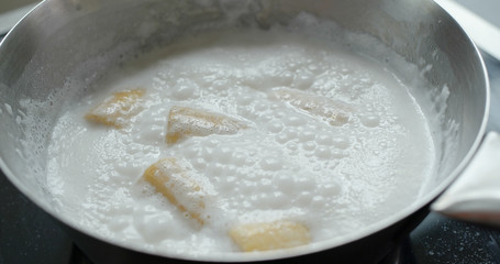 Cook coconut banana dessert in kitchen