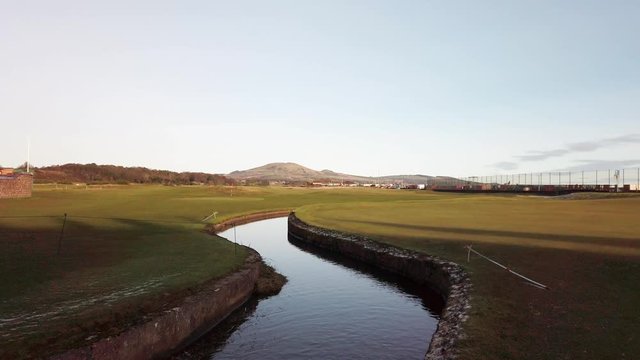 Deserted scottish links golf course with stream running through
