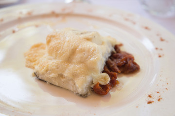 Cod fish in bechamel sauce on plate
