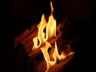  Hot orange flames from a burning log in a fireplace