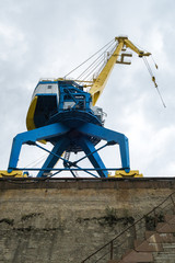 the gantry crane working at the seaport against the clouds