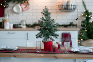 Christmas decoration of the kitchen of the house in the loft style. Decorations with fir branches and garlands