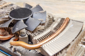 Dust on CPU cooler video card computer close up on wooden table