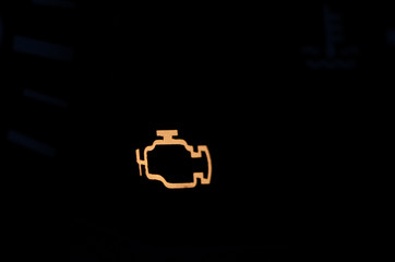 Yellow lit car engine Error sign on black background close up