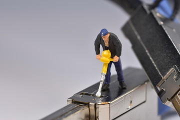 Tiny worker is working on a plug miniature repair scale