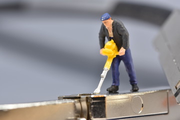 Tiny worker is working on a plug miniature repair scale