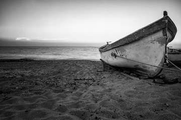 Vintage view of a lonely old boat on the beach