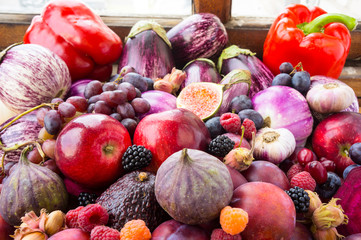 Background of fresh vegetables and fruits. Purple and red food. Different vegetables on the table.