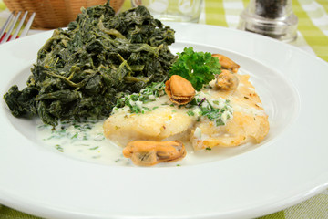 fillet of fish with cream and spinach on a plate