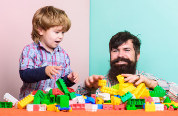 Father and son create colorful constructions with bricks. Child care development and upbringing. Father son play game. Bearded father and boy play together. Dad and kid build of plastic blocks