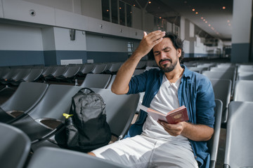 The man is very upset in the waiting room at the gate to the airport.
