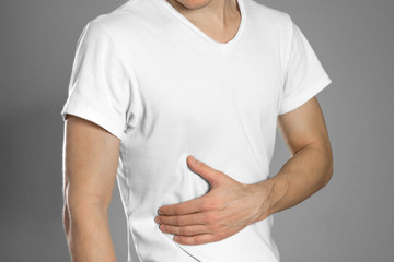Pain in the liver. Cirrhosis. The man holds his side. Close up
